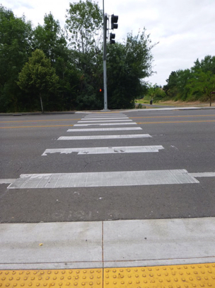 Crosswalk with tactile warnings crosses Hall Blvd. connecting to Greenway Park